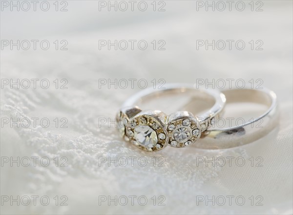 Two wedding rings on bed. Photographe : Jamie Grill