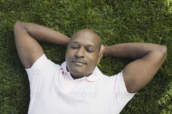 Bald man relaxing on grass. Photographe : PT Images