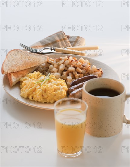 Studio shot of breakfast including eggs with sausages and potatoes.