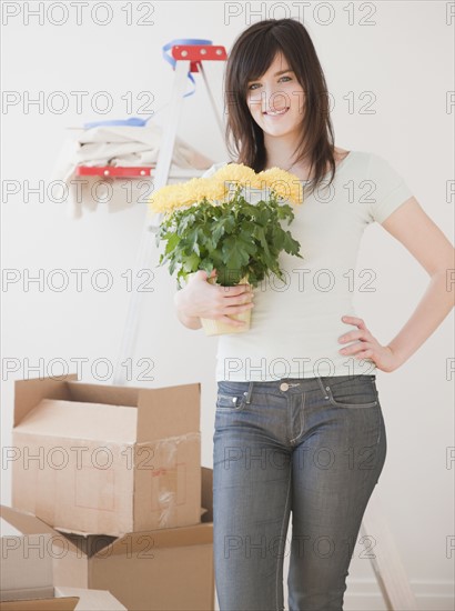 Portrait of young woman redecorating new house. Photographe : Jamie Grill