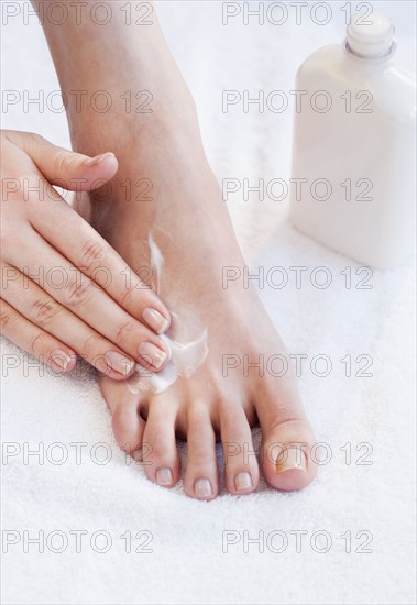 Close-up of woman moisturizing foot.