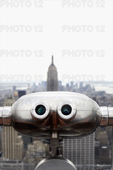Coin operated binoculars pointing at Empire State Building, New York City, New York, USA. Photographe : Joe Clark
