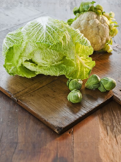 Cauliflower, cabbage and brussel sprouts on wooden table.
