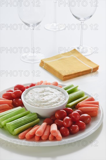 Slices of vegetables on plate with dip.