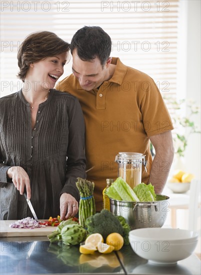 Couple preparing food in kitchen.