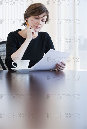 Mature businesswoman reading document.