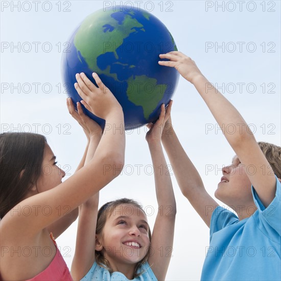 Children holding a globe.