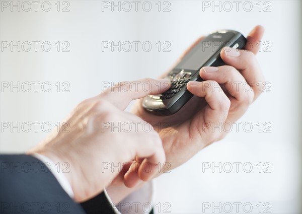 Businessman using personal digital assistant.