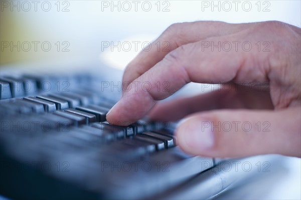 Hand typing on a computer keyboard.