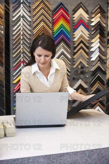 A woman working at a frame store.