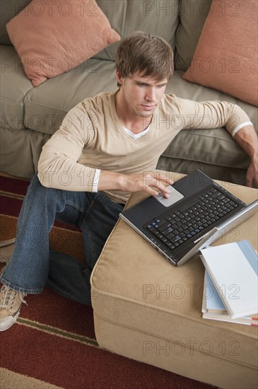 Man using laptop in living room.