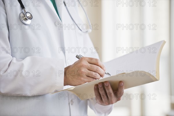 A doctor writing in a file