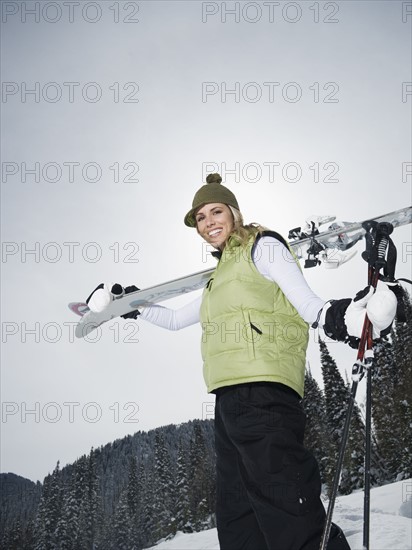 A downhill skier carrying skis