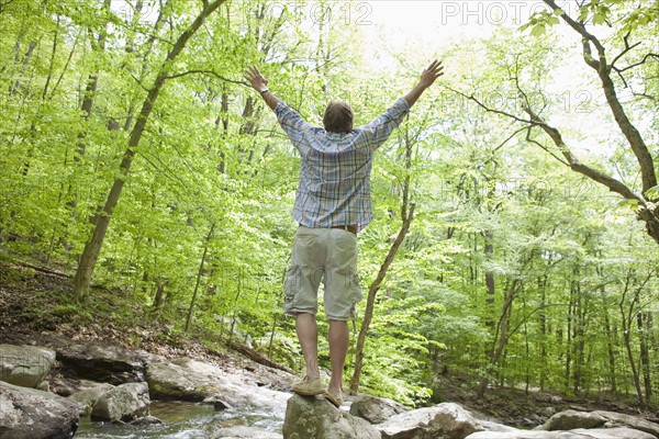 A man at a stream in the woods