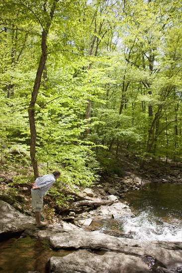 A man at a stream in the woods