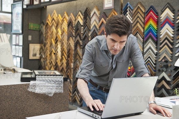 A man working at a frame store.