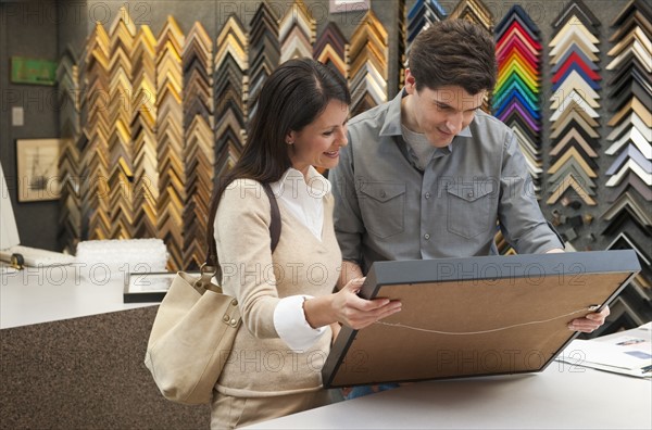 A man and woman at a frame store.