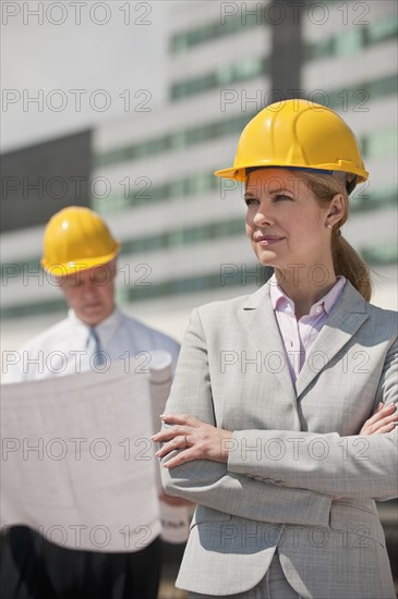 Two architects holding plans outdoors.