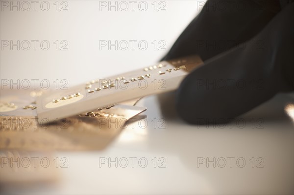 A gloved hand stealing credit cards.