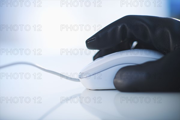 A gloved hand on a computer mouse.