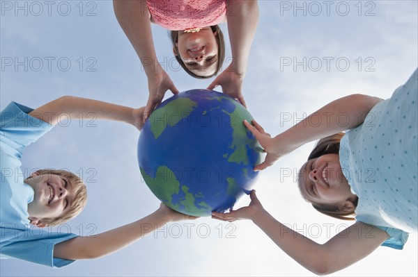 Children holding a globe.