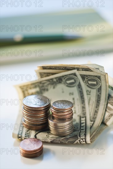 Bank notes and coins by a pad and pen.