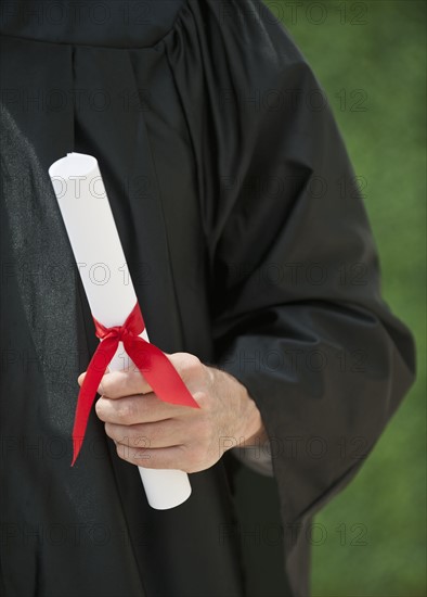 A graduate holding a diploma.