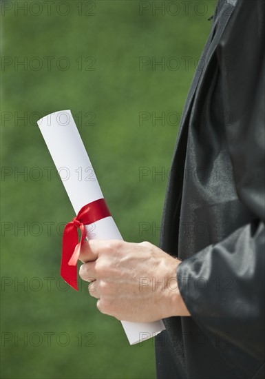 A graduate holding a diploma.