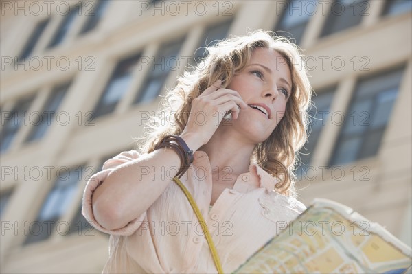 Woman outdoors with a map.