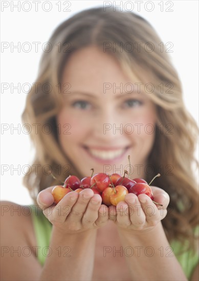 A woman holding cherries.