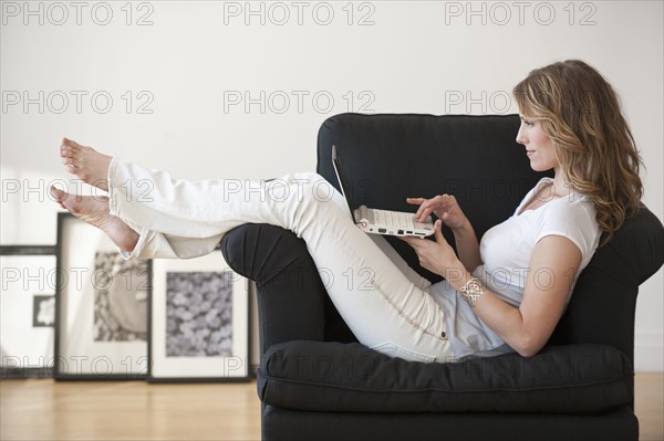 Woman using laptop in living room.