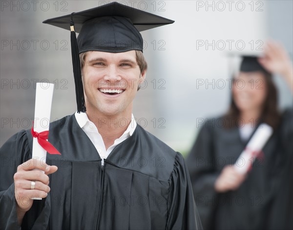 A graduate holding a diploma.