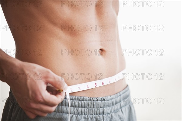 A man measuring his abdomen