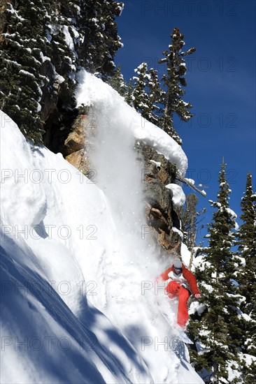A snowboarder coming off a cliff