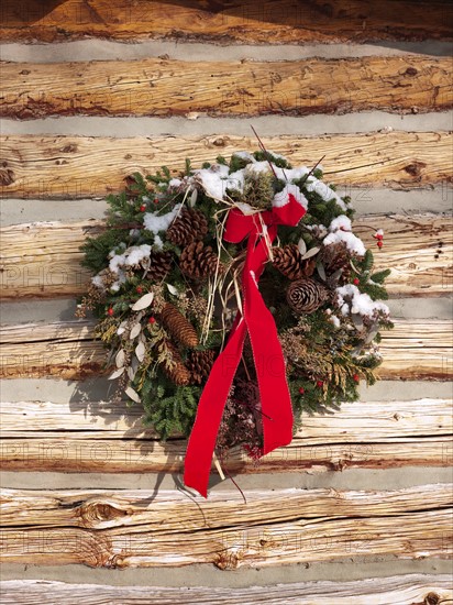 A Christmas wreath on a cabin wall