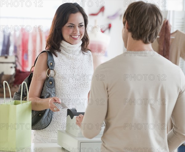 A woman buying clothing at a store.