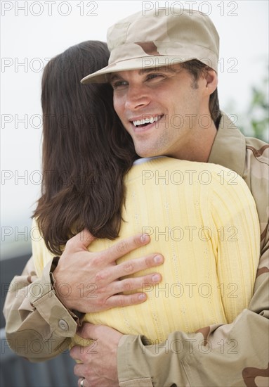 A woman hugging a military officer.