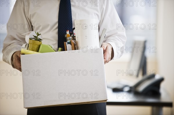 A businessman with a box full of desk stuff