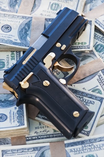 A handgun on stacks of money