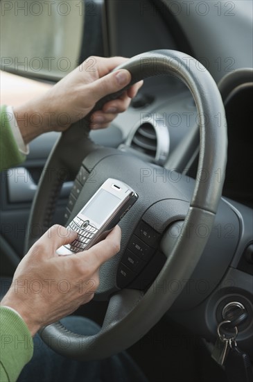 Man using personal digital assistant while driving.