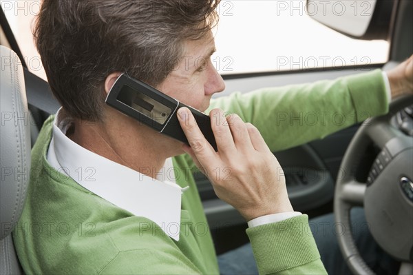 Man using cellular phone while driving.