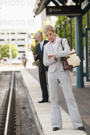 Two business people at a train station.