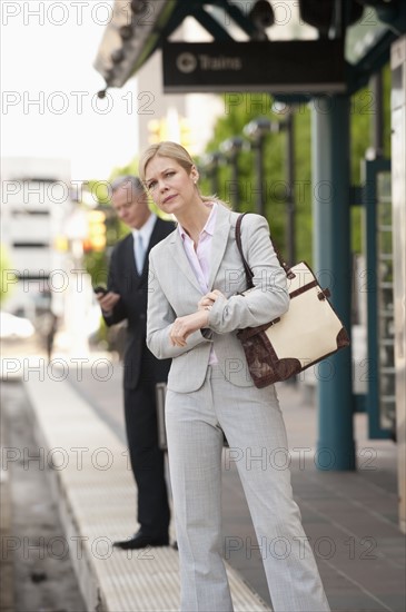 Two business people at a train station.