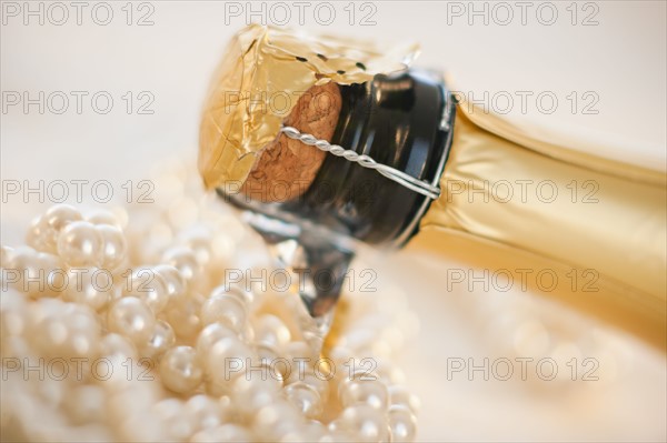 Champagne bottle and pearl necklace.