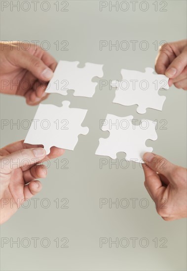 Hands holding puzzle pieces.