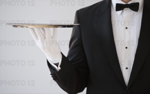 A server holding a silver tray.