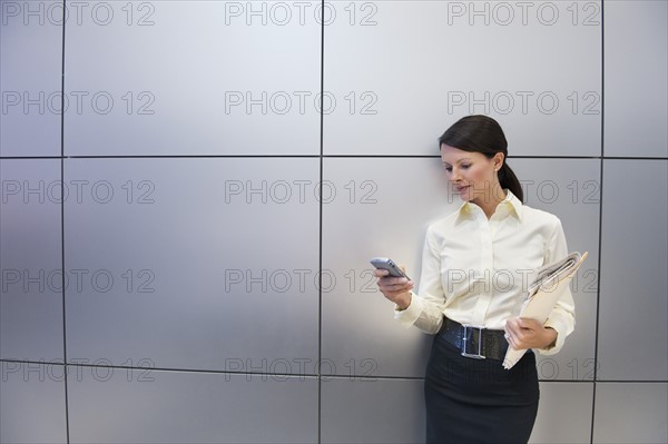 A businesswoman using a personal digital assistant.