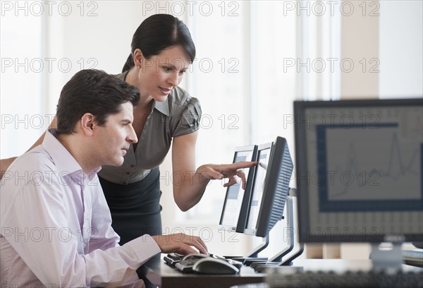 Two business people using a computer.