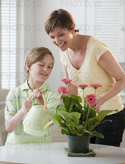 Mother and chilld watering plants.