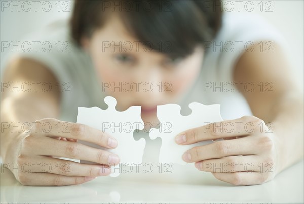 Woman holding puzzle pieces.